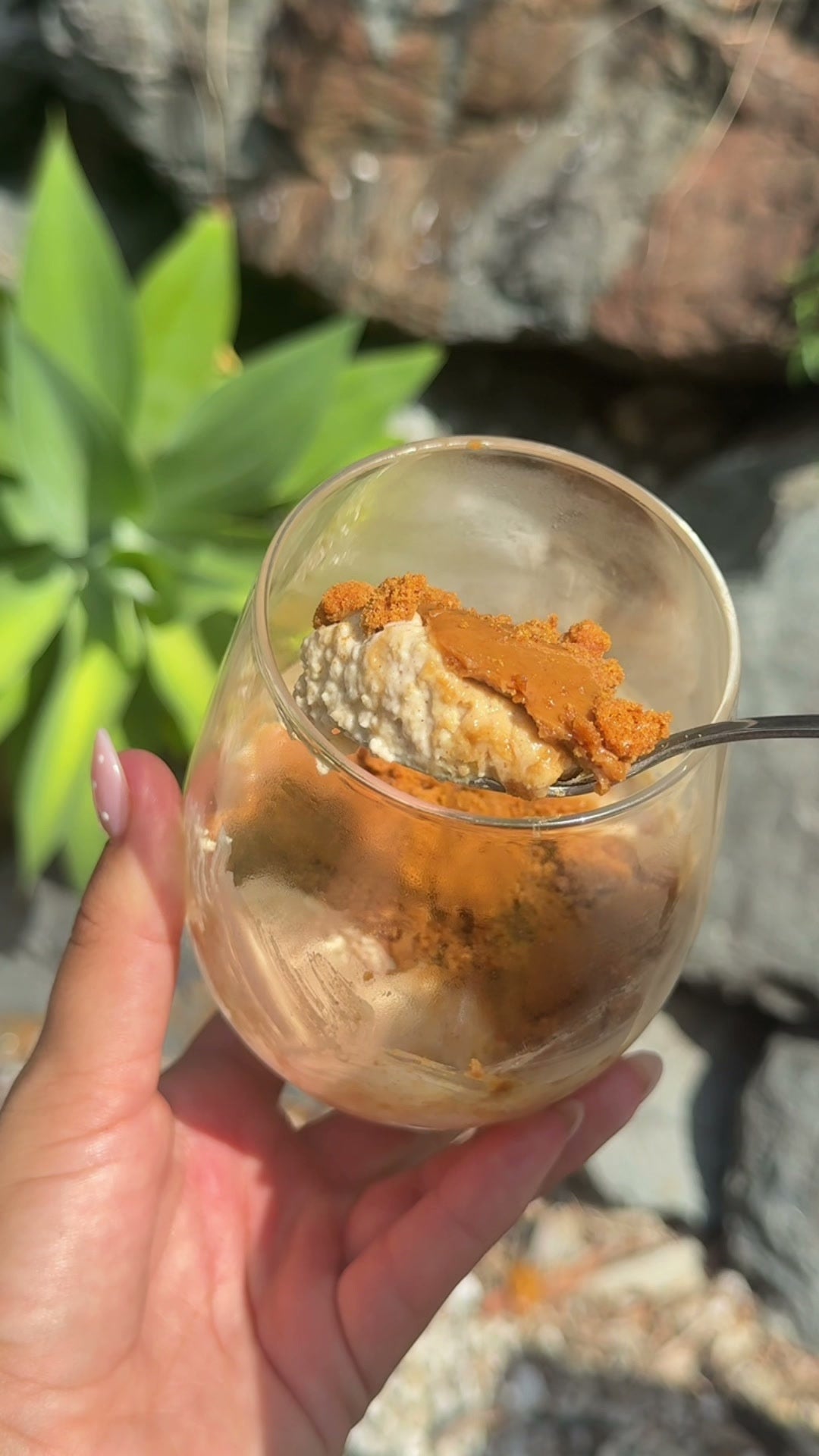Creamy Biscoff protein oats in a glass topped with Biscoff spread and crumbled biscuit