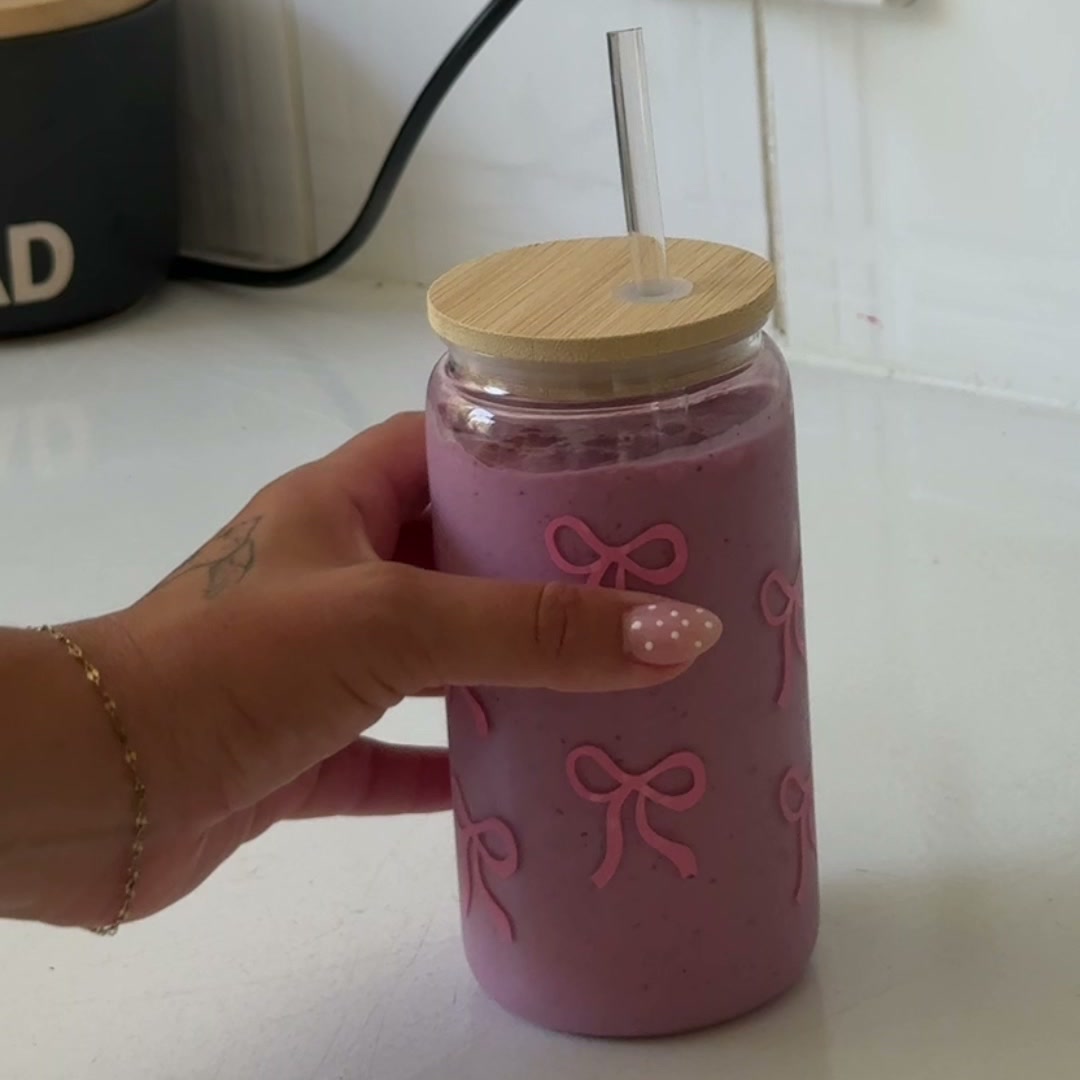 Mixed berry protein smoothie in a glass tumbler with a straw