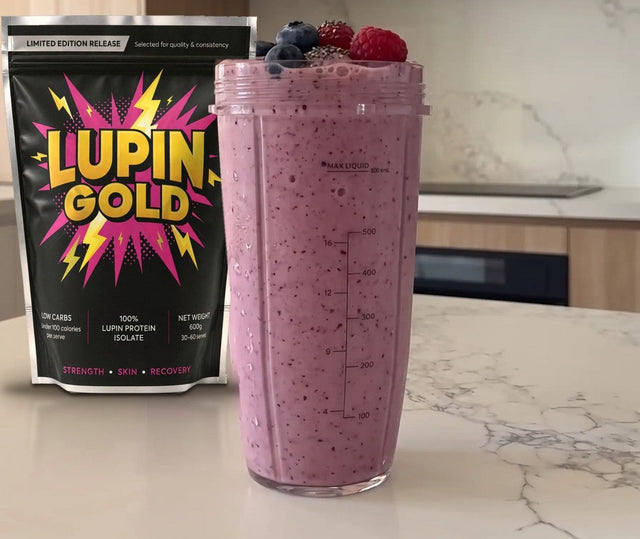 Berry yoghurt protein smoothie in a blender cup beside a pack of Lupin Gold protein isolate