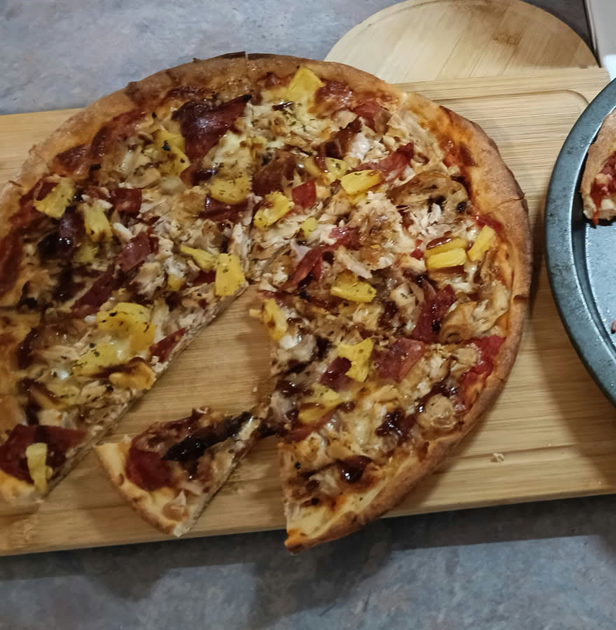 Homemade pizza on a wooden board with a crisp golden lupin protein crust