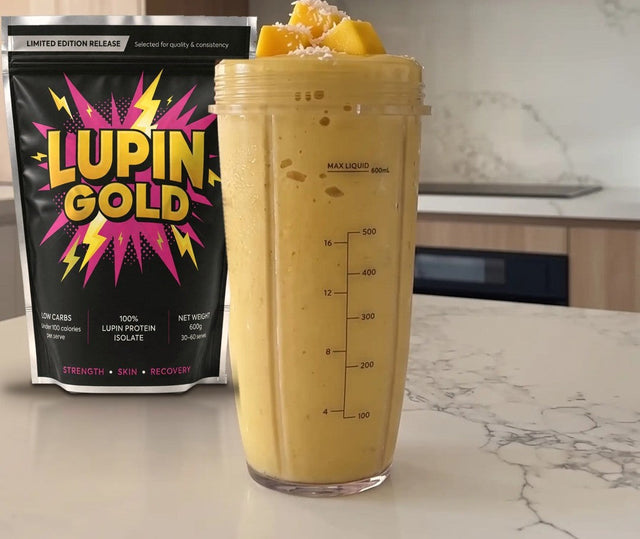 Mango coconut protein smoothie in a blender cup beside a pack of Lupin Gold protein isolate
