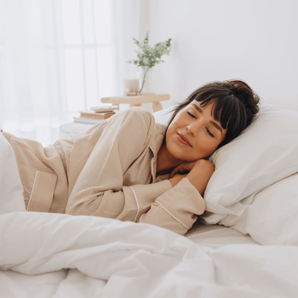 Woman lying on a bed in a cozy bedroom with soft lighting