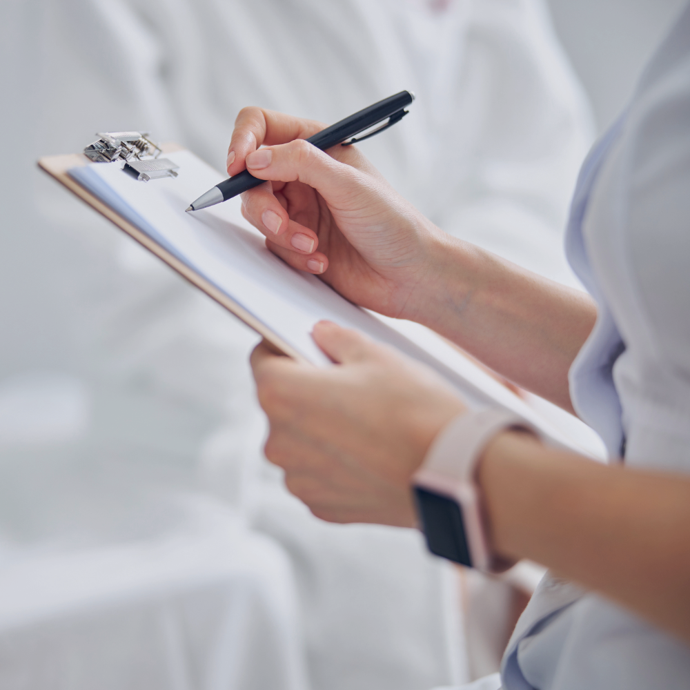 Person holding a clipboard and pen with a blurred background